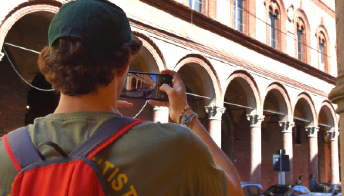 ragazzo di spalle che fotografa i portici